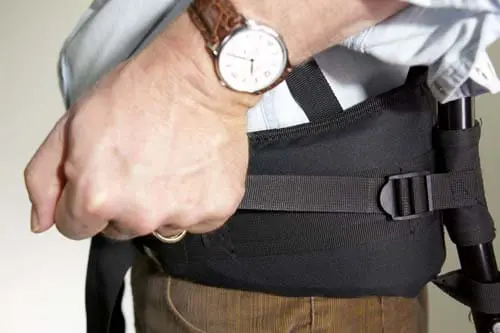 Side view of a man holding a Belt Buckle to Tighten